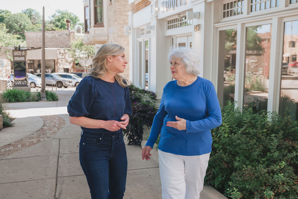 Robyn walking with an older woman in a blue sweater