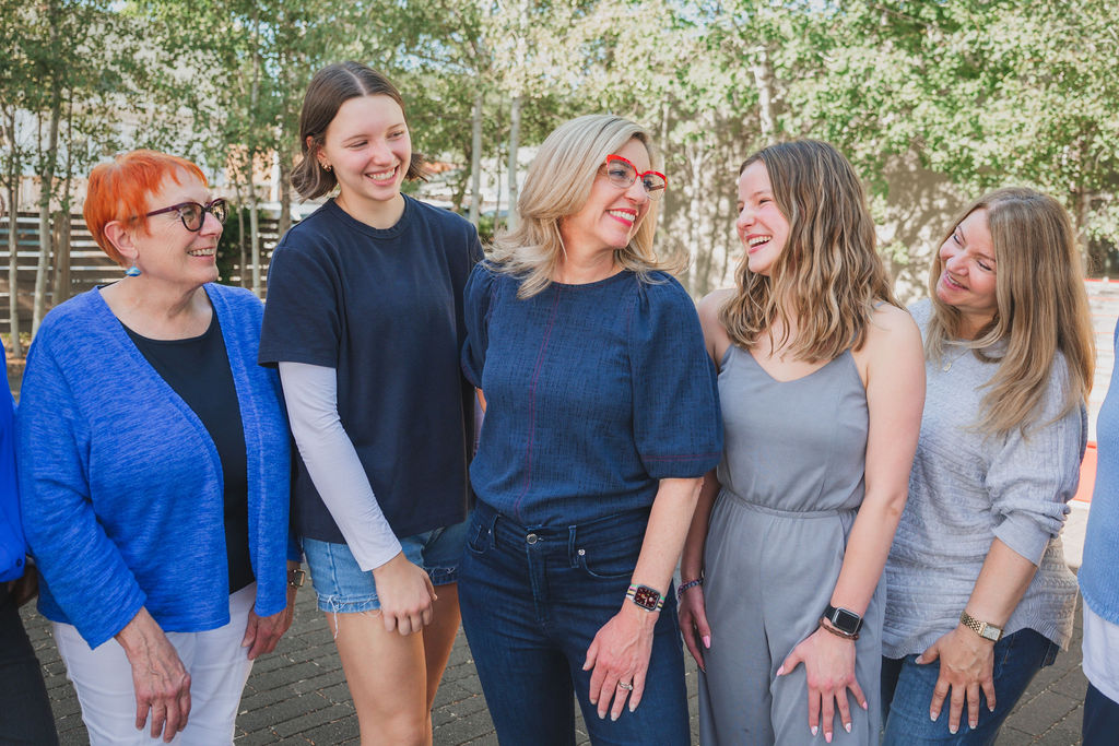 Robyn standing in front of a group of people, all smiling at the camera